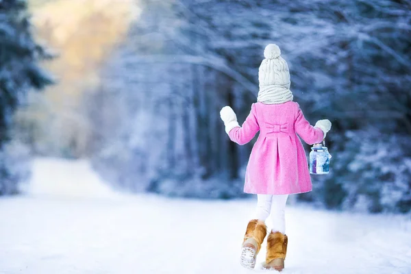 Adorable fille avec lampe de poche et bougie en hiver la veille de Noël en plein air — Photo