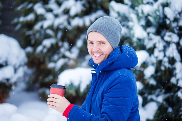 Ung kaukasiska man dricka kaffe i kall vinter dag utomhus — Stockfoto