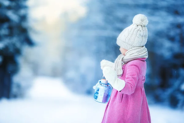 Adorable little girl with flashlight and candle in winter on Christmas outdoors — Stock Photo, Image