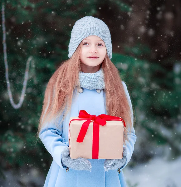 Adorable niña con regalo de caja de Navidad en invierno al aire libre en Nochebuena — Foto de Stock