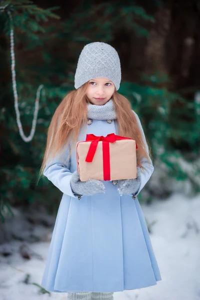 Petite fille avec cadeau de boîte de Noël en plein air en hiver — Photo