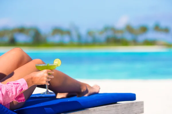 Young woman with tasty cocktail on beach loungers during maldives vacation — Stock Photo, Image