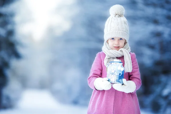 Adorable niña con linterna y vela en invierno en Navidad al aire libre —  Fotos de Stock