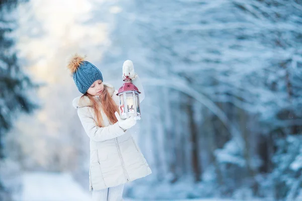 Bedårande liten flicka med ficklampa på jul på winter forest utomhus — Stockfoto