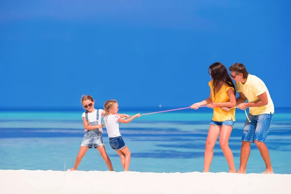 Familia feliz jugando en la playa tropical blanca — Foto de Stock