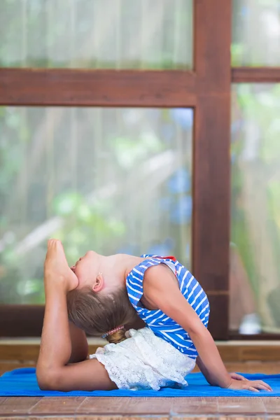 Küçük kız terasta yoga egzersizi yapıyor. — Stok fotoğraf
