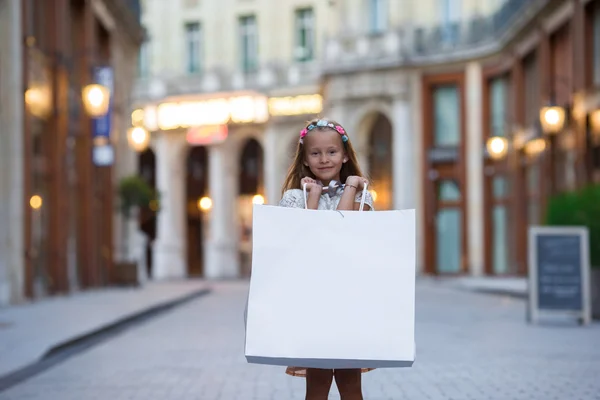 Чарівні дошкільного дівчина, що йде з сумками у Парижі на вулиці — стокове фото