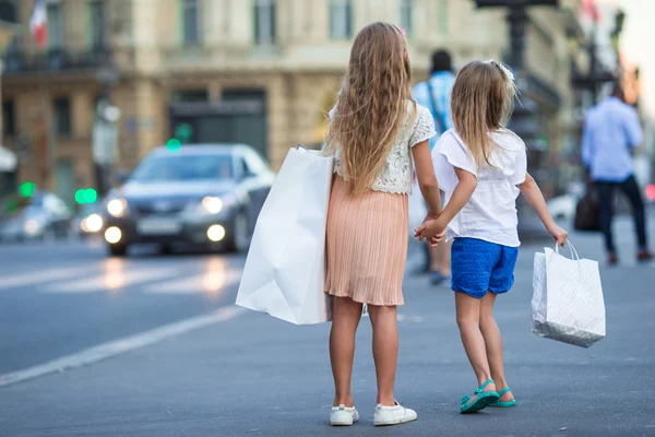 Adorable fashion little girls with packages outdoors in European city — Stock Photo, Image