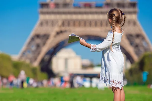 Entzückendes kleines Mädchen mit Karte von Paris im Hintergrund der Eiffelturm — Stockfoto