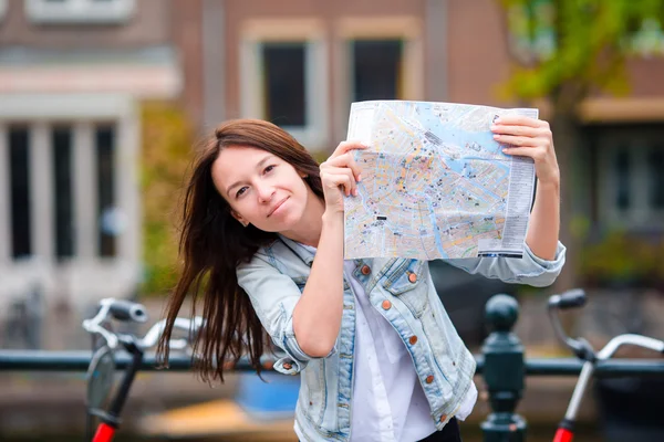 Mujer joven y feliz con un mapa de la ciudad europea — Foto de Stock