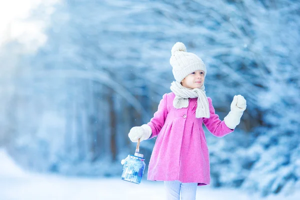 Adorable chica con linterna y vela en invierno en Nochebuena al aire libre —  Fotos de Stock