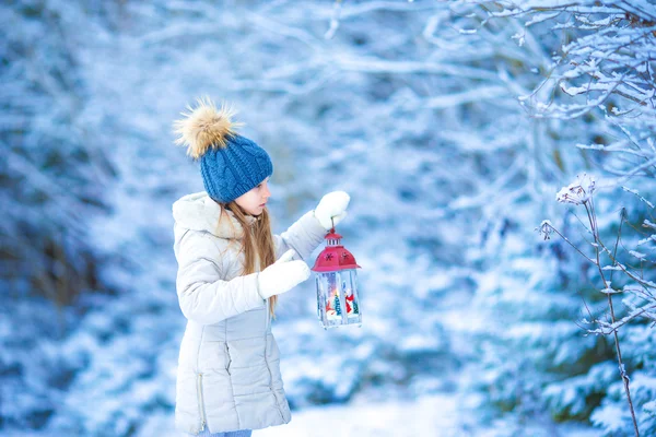 Liten flicka med ficklampa och ljuset i vinter dag utomhus — Stockfoto