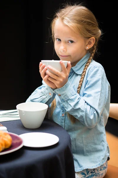 Entzückendes kleines Mädchen frühstückt im Café — Stockfoto