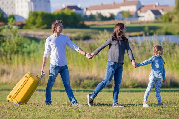 Lycklig familj med bagage gör dig redo för att resa utomhus — Stockfoto