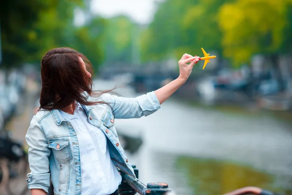 Woman with airplane model background of canal in Amsterdam, Netherlands — Stock Photo, Image