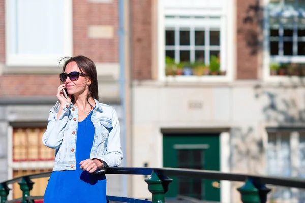 Jeune femme caucasienne parlant par téléphone cellulaire dans la ville européenne — Photo