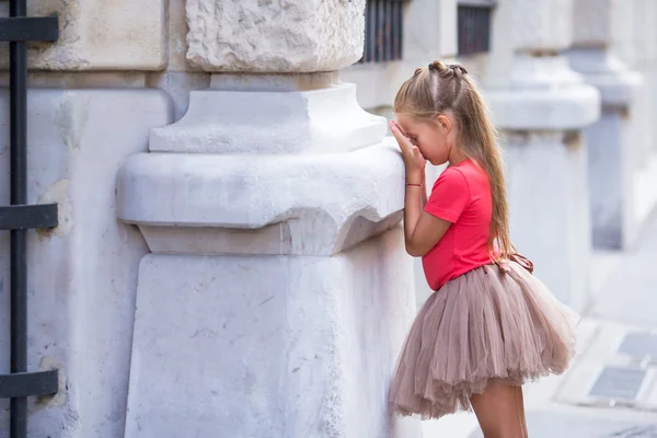 Malá holka hraje na schovávanou na ulici v Paříži venku — Stock fotografie