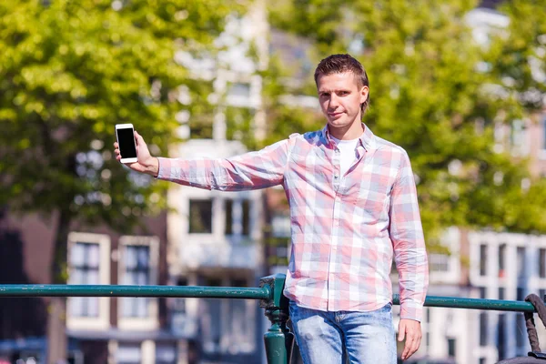 Kaukasische jongeman met telefoon in Europese stad — Stockfoto