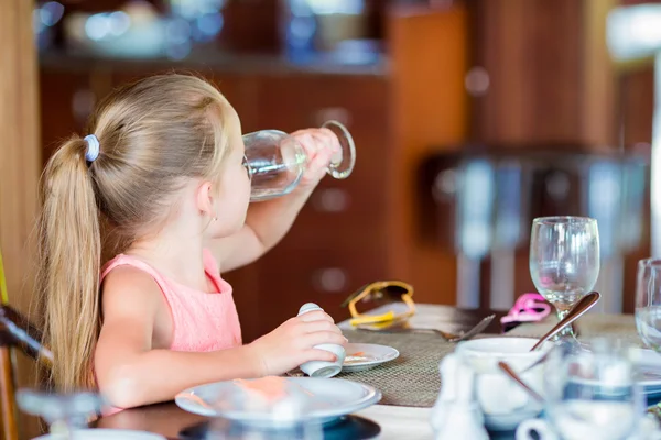Dziewczynka ma śniadanie wody pitnej w kawiarni na świeżym powietrzu — Zdjęcie stockowe
