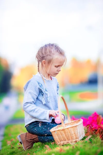 Entzückendes kleines Mädchen auf der Suche nach Ostereiern im Freien — Stockfoto