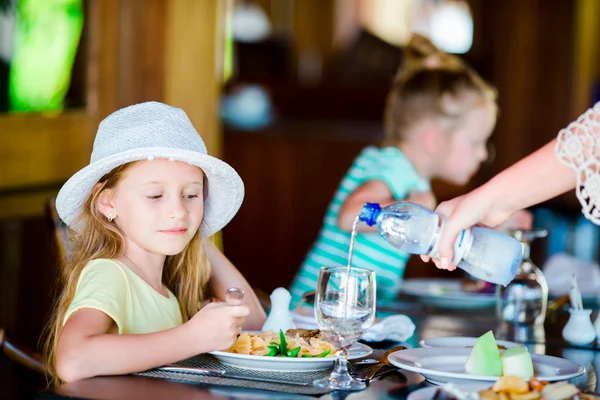 Adorable niña tomando el desayuno en la cafetería al aire libre —  Fotos de Stock