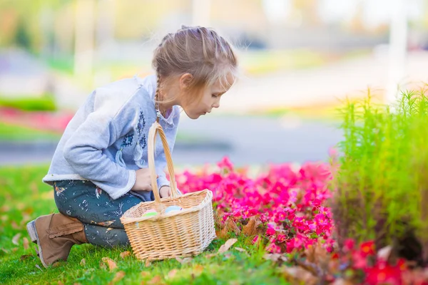 Adorable petite fille à la recherche d'œufs de Pâques en plein air — Photo