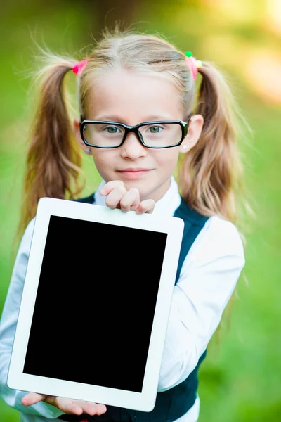 Bedårande liten flicka håller tablet Pc utomhus i soliga höstdag — Stockfoto