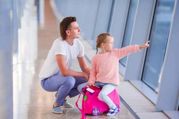 Familia feliz con equipaje y tarjeta de embarque en el aeropuerto esperando el embarque —  Fotos de Stock