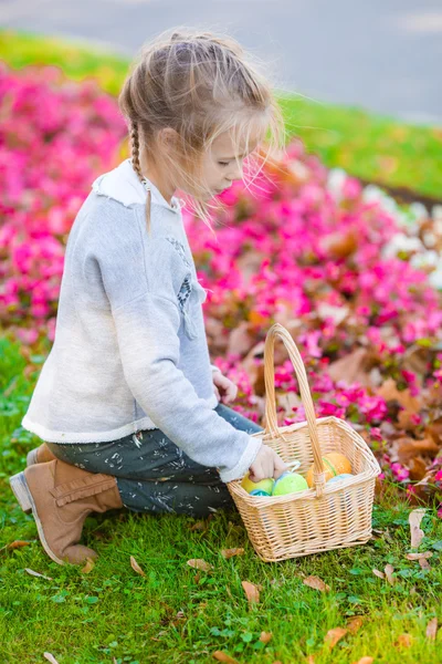 Adorable little girl looking for Easter eggs outdoors — Stock Photo, Image