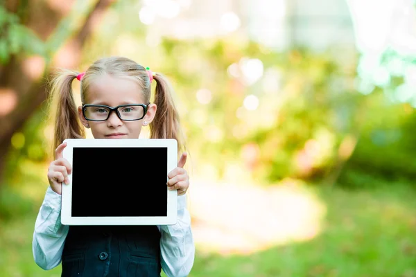 Bedårande liten flicka håller tablet Pc utomhus i soliga höstdag — Stockfoto