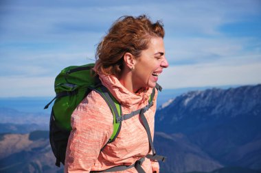 Saçları rüzgarda savrulan, dağlarda gülen bir kadının portresi. Karpatya dağlarında yürüyüşçü kız.