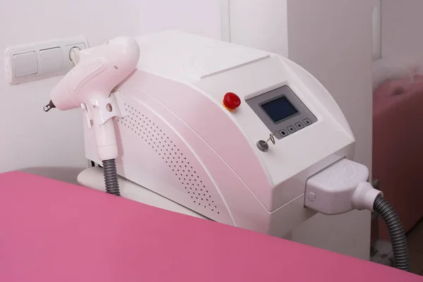 Lasertatueringsborttagningsmaskin i salongen. Rosa soffa på bakgrunden. — Stockfoto