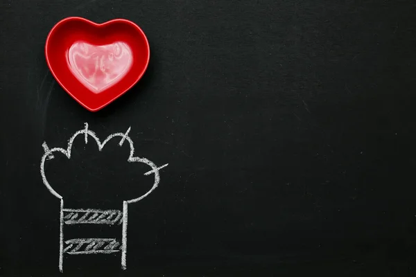 黒の黒板に白で描かれた猫の足の赤い心。バレンタインデーグリーティングカードの背景壁紙. — ストック写真