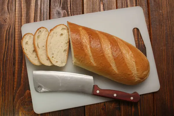 Wit brood brood brood zelfgemaakt warm rustiek smakelijk lekker in de oven op een snijplank op een houten achtergrond — Stockfoto