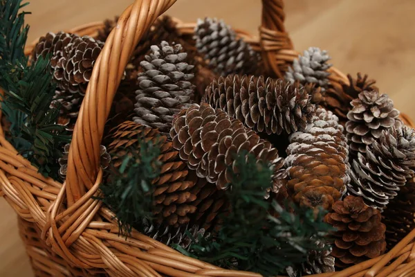 rustic handmade basket with pine cones on wooden background