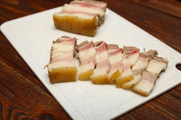Dill, szeletek sózott disznózsír, darab zsír, szeletek kenyeret rózsaszín műanyag vágódeszka elszigetelt fehér háttér. Felülnézet — Stock Fotó