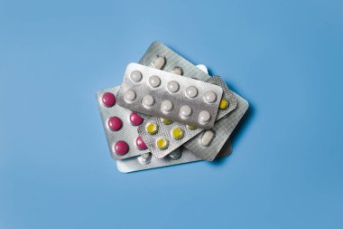 Mavi üzerine izole edilmiş çeşitli haplar içeren dağınık su toplayıcılarının üst görünümü