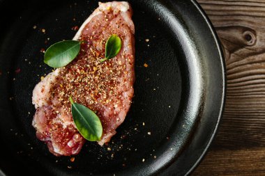 Biftek, ahşap bir masada şiş pişirmeden önce baharatlı çiğ ettir..