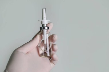 Doktorların burun spreyi beyaz bir tıbbi eldiven verir. Burun akışının tedavisi için ilaç, nefes alma rahatlığı.