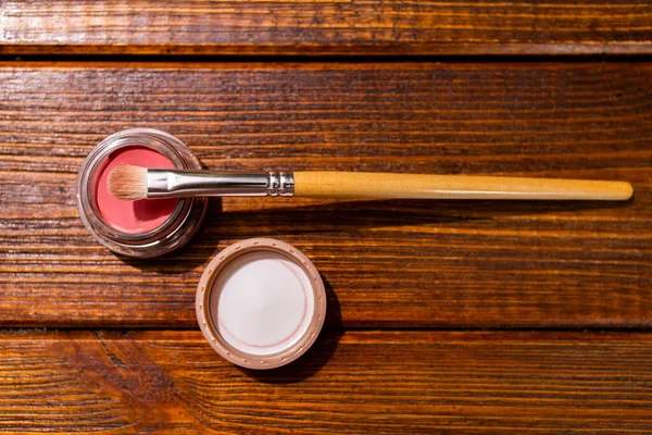Blush or lipstick, makeup powder pink powder and brush to apply.