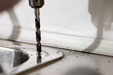 Metal için matkap, çelik lavaboda delikler açar. Su filtresi takılıyor.