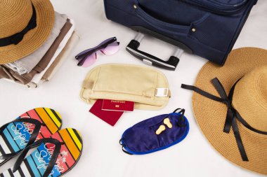 Şapka, güneş gözlüğü, parmak arası terlik ve plaj aksesuarları. Bagaj, seyahat eşyaları, bavul ve şapka. Tatile ya da seyahate hazırlanma.