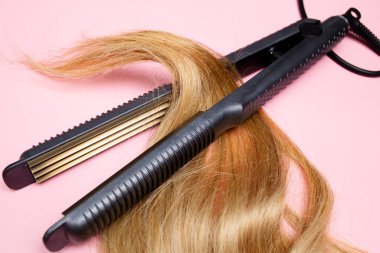 Saç maşası. İnce saçlar ses çıkarıyor. Kuaför aletleri. Düzeltme araçları
