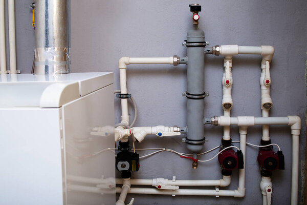 Heating system of a private house, boiler room with gas equipment, water pipes. Dispensing vessel container.
