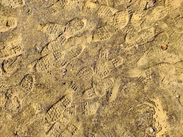 湿沙上的靴子脚印.印品的纹理、背景墙纸、雨后脏沙. — 图库照片