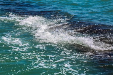 Dalgalı deniz kapanıyor. Bir sürü deniz köpüğü sahnesi olan güzel mavi dalgalar yukarıdan, yakından baktı. Mavi denizde köpük. Güzellik
