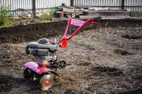 Cultivador de motores para excavar la tierra. Plantación de primavera y excavación en la tierra húmeda. Jardín y huerta. Cultivo de cultivos. Cosecha de otoño y primavera —  Fotos de Stock