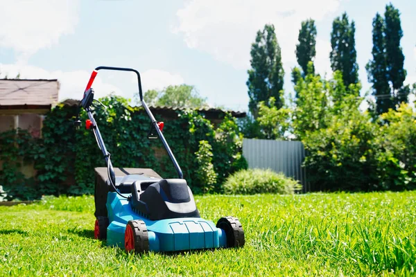 Gazonmaaier elektrische machine trimmen groen gras. Grasmaaien — Stockfoto