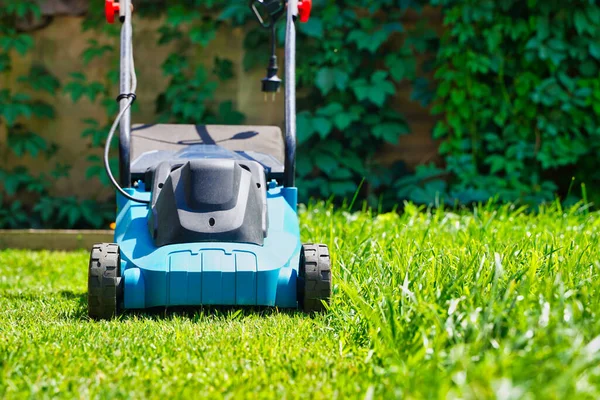 Lawnmower electric machine trimming green grass. Lawn cutting — Stock Photo, Image