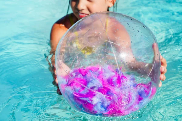 Inflatable beach ball transparent with pink feathers inside floating on the surface of the open sea pool — Stock Photo, Image